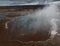 Steaming geysir with a beautiful view of the landscape
