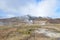 Steaming geysir with a mountain in the background