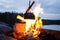 Steaming pot on bonfire. Cozy camping place in wild near the lake.