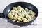 Steaming roasted cauliflower florets in a frying pan, cooking vegetables for a healthy vegetarian dish, selected focus