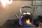 Steaming water in Traditional metal kettle on fire on gas stove