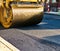 Steamroller compacts asphalt in road repaving project.