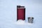 Steel alcohol flask in the winter forest. men`s accessory for alcohol