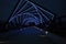 Steel arches above High Trestle Trail in Iowa light up in blue after sunset as darkness falls.