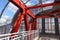 Steel beams in red against a blue sky. Overhead passage. Industrial background