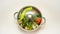 Steel casserole dish, filled with various vegetables and covered with a glass lid, close-up