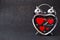 Steel clock alarm in the form of a heart with red hearts inside on a black glitter shiny background. Happy Valentine`s Day