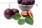 Steel colander with ripe plums, whole and half ripe plums with l