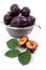 Steel colander with ripe plums, whole and half ripe plums with l