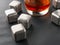 Steel cubes imitating ice. For cooling drinks. With a glass of whiskey. Covered with drops. Close-up
