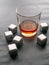 Steel cubes imitating ice. For cooling drinks. With a glass of whiskey. Covered with drops. Close-up