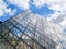 Steel frame and glass panes of Louvre pyramid towering skyward in Paris, France
