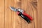 Steel gardening secateurs, scissors tool with red and black grip for pruned of plants and flowers garden work, on a wooden table