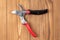 Steel gardening secateurs, scissors tool with red and black grip for pruned of plants and flowers garden work, on a wooden table