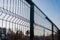 Steel grating fence made with wire on blue sky background. Sectional fencing installation.