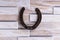 Steel horseshoe on a wooden background, brings luck, symbol