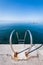 Steel ladder on pier with turquoise adriatic ocean in Triest