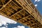 Steel lattice construction of a railway bridge on a background of blue sky with white clouds.