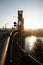 Steel lift bridge over sunbathed river into a city