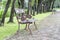 Steel long chair in the park with grass and brick .