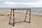 Steel metal football goal gate on sea sand