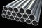 Steel metal profiles in pipe shape isolated on black - industry concept