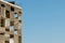 Steel metallic structure of the buildings corner against clear blue sky backlit by sun