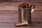 Steel mug and wooden scoop for coffee beans.