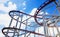 Steel rails for driving roller coasters in circular motions, on background blue sky and sun shining, concept relaxation and