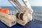 Steel reel of a crane on a deck of sailing ocean ship with sea horizon in the background.