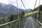 Steel rope suspenion bridge spanning the gorge in a mountain landscape