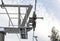 Steel ropes over wheels in mechanism on top of ski chair lift support pillar, bright sky background