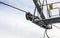 Steel ropes over wheels in mechanism on top of ski lift support pillar, number 5 on yellow plate. Wide banner with space for text