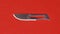 Steel scalpel blade on red background