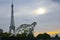 A steel sculpture of a Tyrannosaurus Rex under the Eiffel Tower.