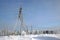 Steel structure of the power line  and winter forest on the horizon