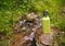 Steel thermos with water on stone near mountain river