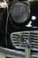 Steel wire grille protected round headlight of Triumph TR3 veteran two seated british sports car, black colour.