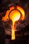 Steel worker in protective clothing raking furnace in an industrial foundry