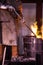 Steel worker raking furnace in an industrial foundry