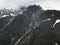 Steep Glacially Polished Cliffs And Mountain Peak Covered With Snow And Clouds, Alaska