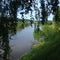 Steep green banks by a calm, deep river.