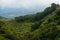 Steep green valley viewpoint leading to blue ocean