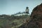 Steep high lava rock cliffs on on the east of Tenerife. Sea lighthouse, natural sky background