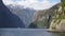 Steep mountain cliffs in Milford Sound Fiordland National Park, New Zealand.