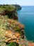 Steep rocky shore and vertical cliffs hanging over the water at Cape Kaliakra