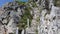 Steep stairway carved out of stone on a mountain path. Steel cables on its sides. Orobie. Italian Alps