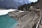 Steep stone shore and reflection of snowy panorama of Alps in KlÃ¶ntalersee lake