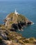 Steep stone steps leading to a white lighthouse on the cliffs a rugged coastline. South Stack Lighthouse