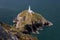 Steep stone steps leading to a white lighthouse on the cliffs a rugged coastline. South Stack Lighthouse